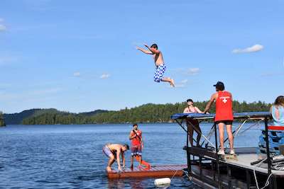 young boy diving at Canadian adventure camp lake